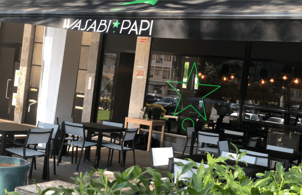 Esplanada do Wasabi Papi com o logótipo e estrela verde em néon
